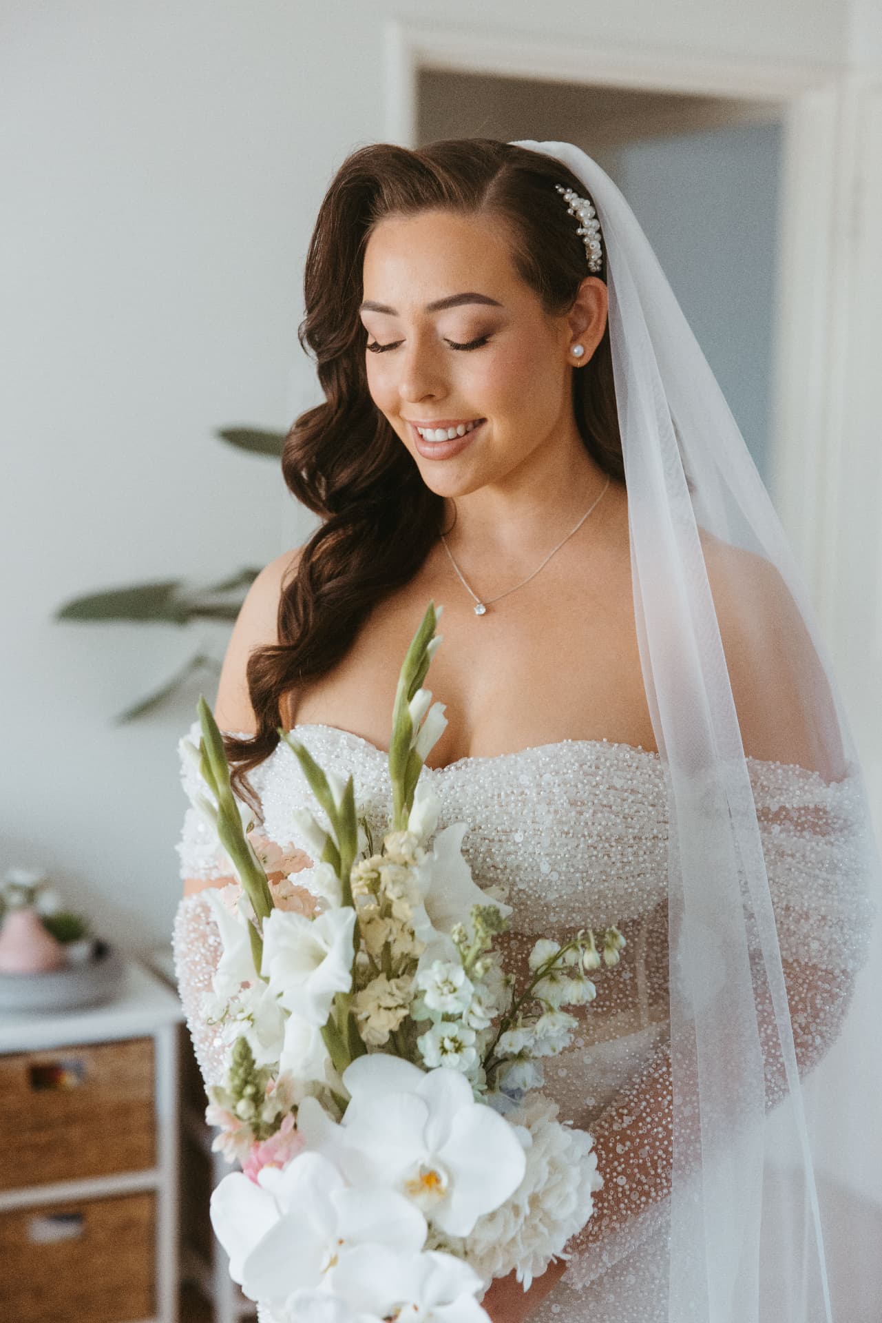 Bride with Hollywood waves and a long cathedral veil holding her bouquet