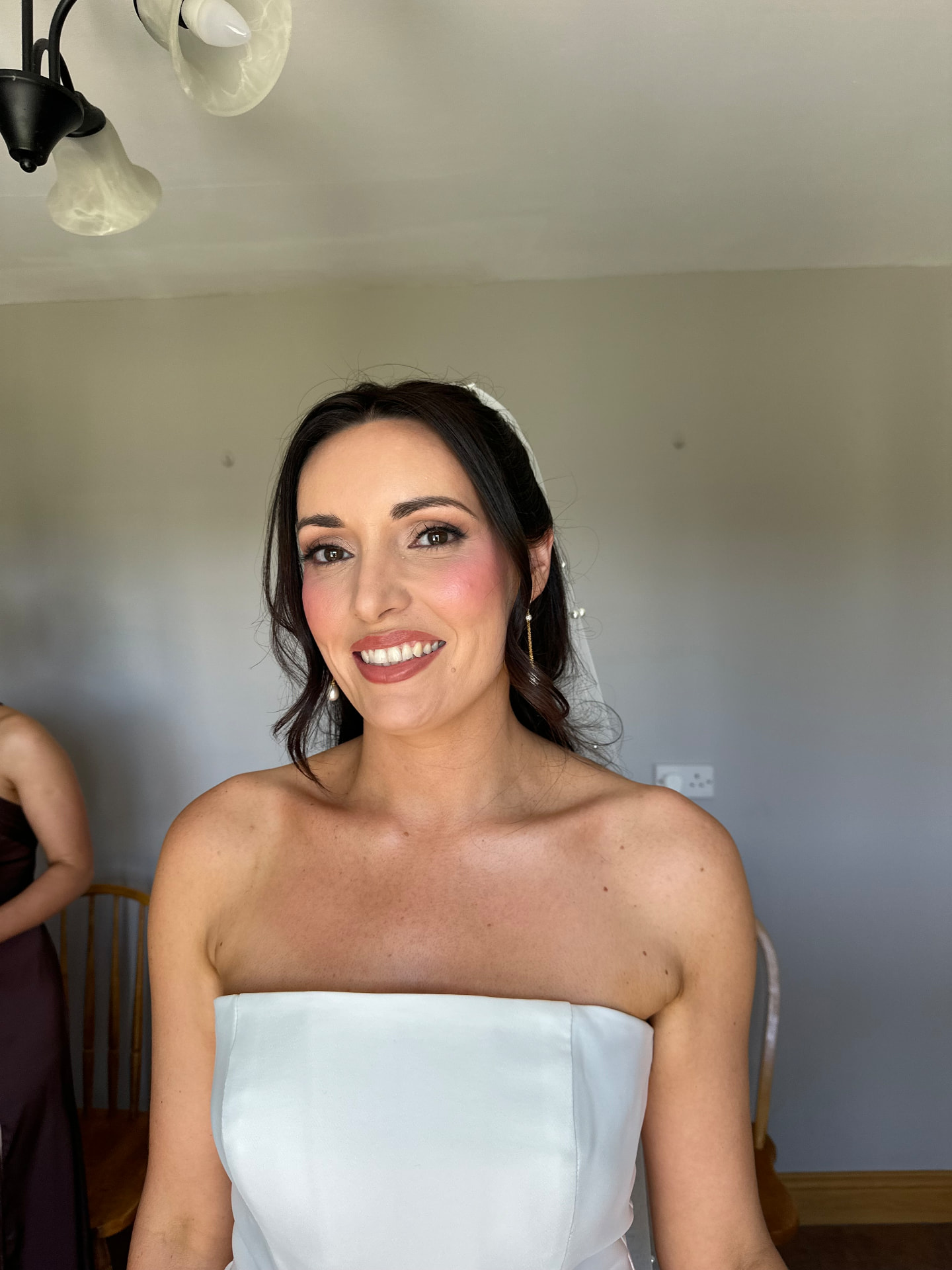Real bride in her gown and veil with warm blush, defined eyes and a rosy lip