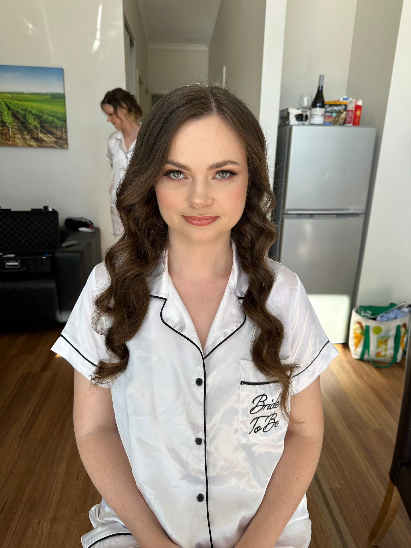 Real bride in bride-to-be pyjamas with long bouncy brunette curls and fresh soft glam makeup