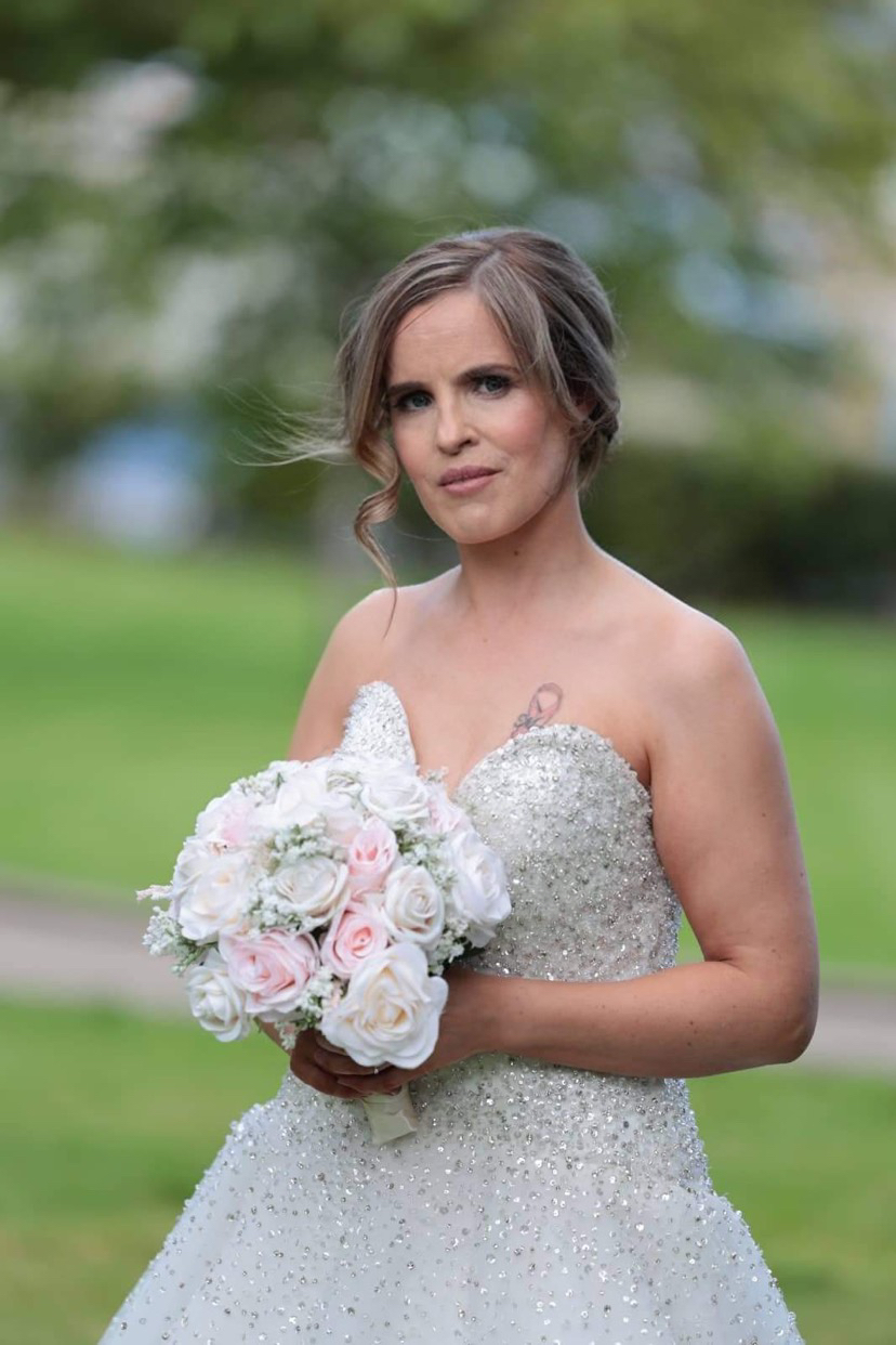 Real bride in a sparkling gown with a soft romantic updo and face-framing tendrils