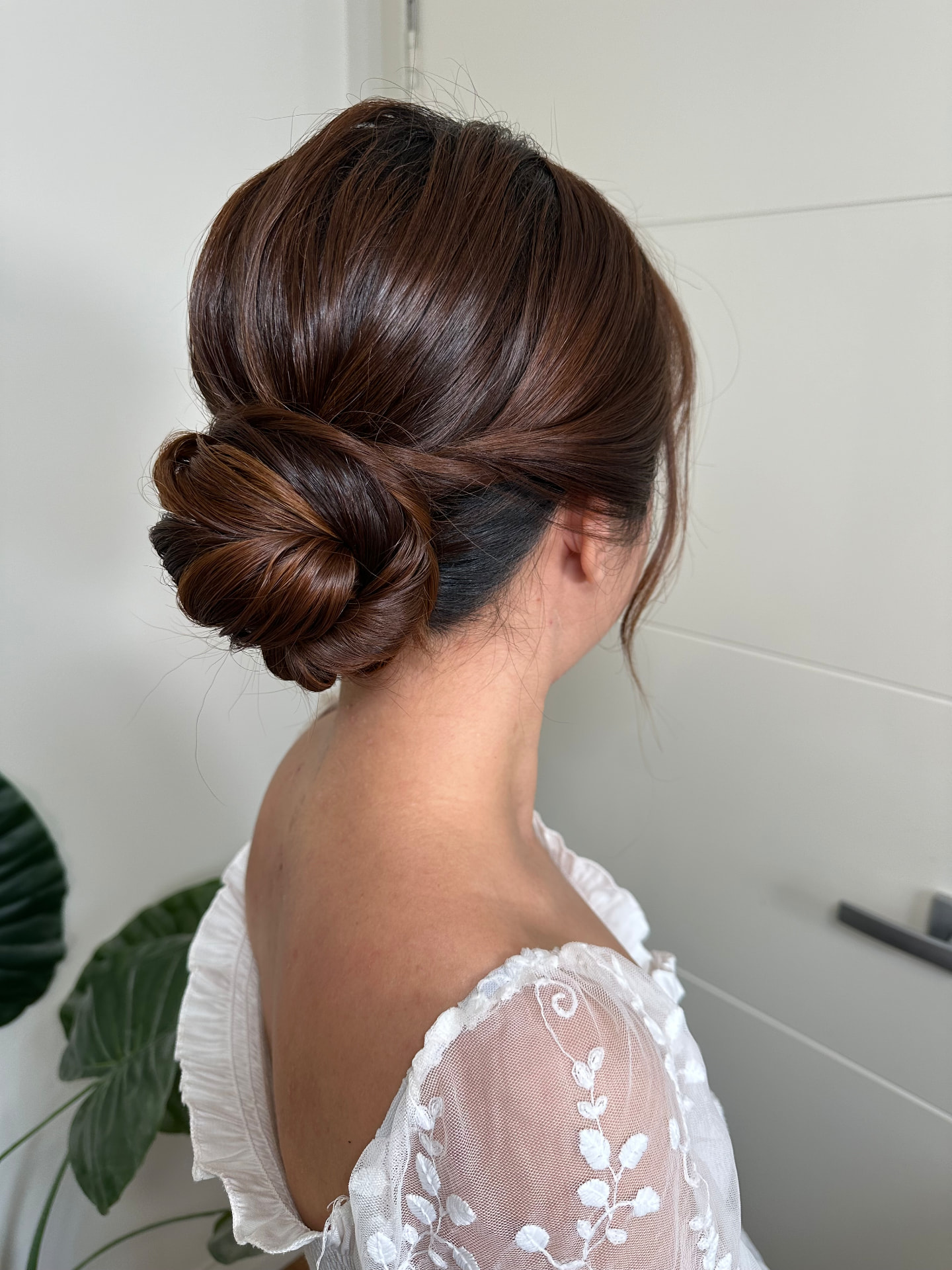 Back view of a sleek dark brunette bridal low bun