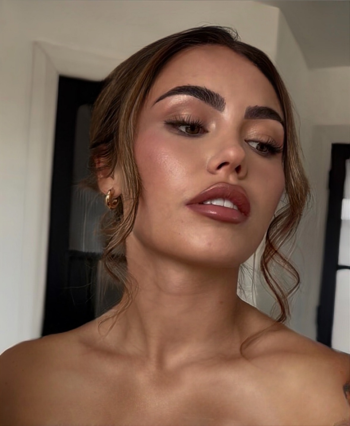 Bride with glowing bronzed skin, soft smoked liner and a glossy nude lip