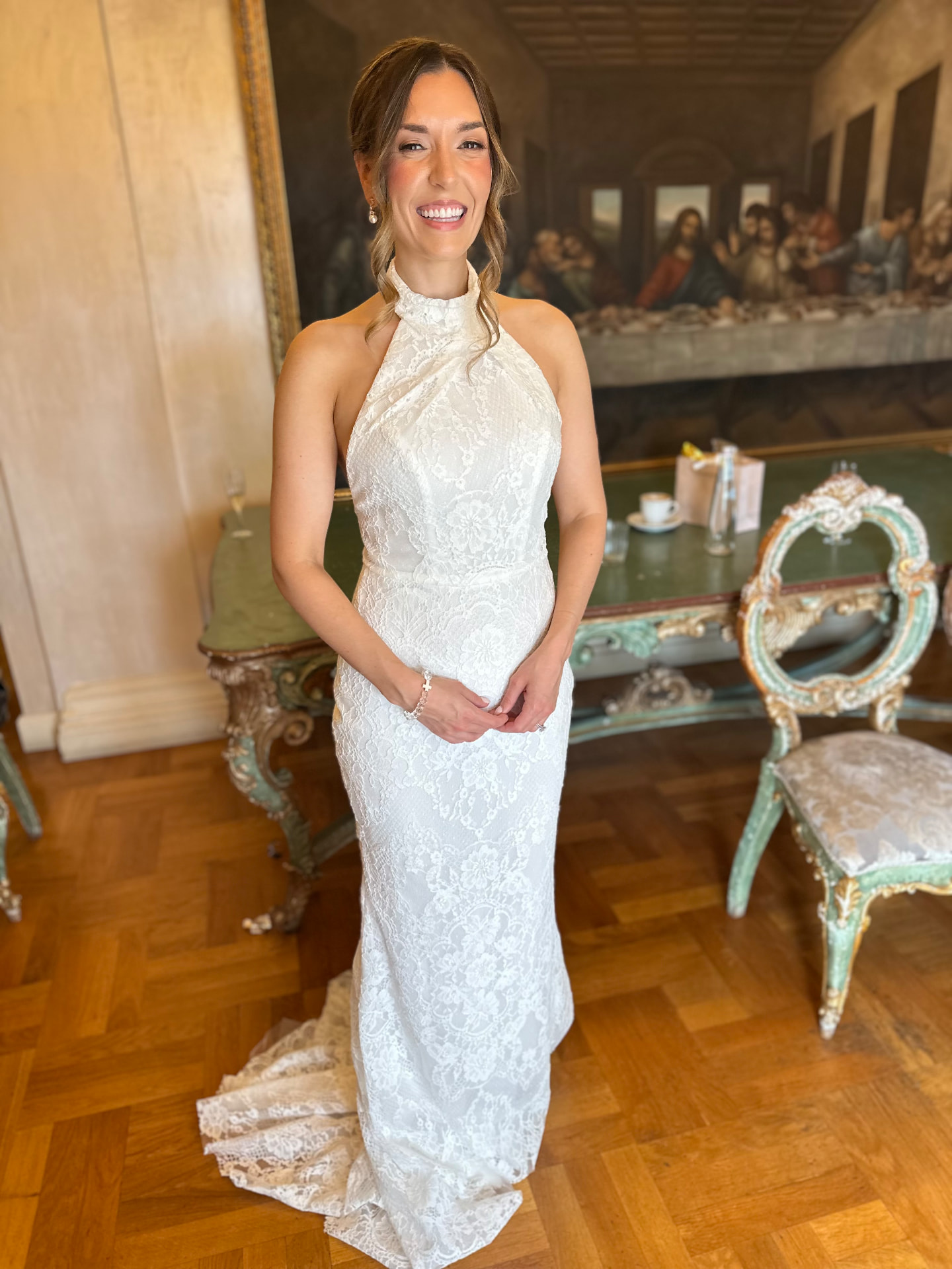 Lauren on her wedding day in a lace halterneck gown with a soft twisted updo and luminous soft glam makeup